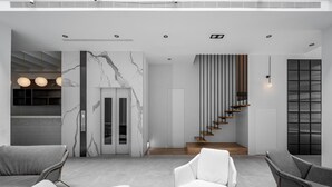A modern interior with a marble wall, a staircase, and seating areas. - Black Horn B&B (Hengchun)