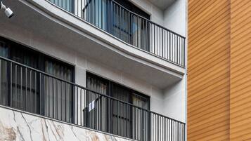 A multi-story building with balconies, large windows, and a marble facade.