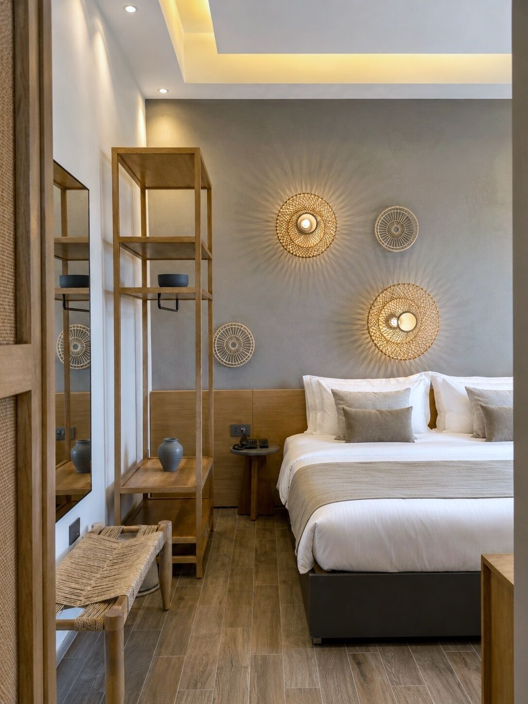 A modern bedroom with a bed, bedside tables, a wooden shelf unit, and decorative wall lights.