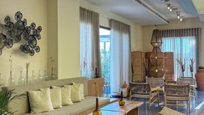 A spacious living area with a sofa, coffee table, and wicker chairs.
