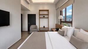 Une chambre d’hôtel moderne dotée d’un grand lit, d’un bureau, d’une chaise, d’une télévision et offrant une vue sur la ville.