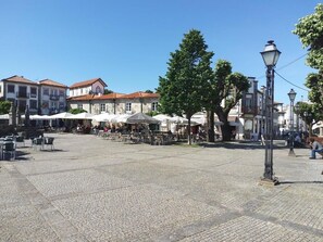 An open public square with tables and chairs, surrounded by buildings with traditional architecture.