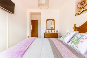 A bedroom with a bed, dresser, and a mirror.