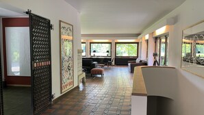 A spacious living area with a tiled floor, a sofa, a coffee table, and a fireplace. - House (Lohmar)