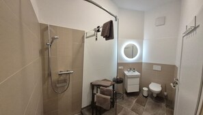 Une salle de bain équipée d’une douche, d’un lavabo, de toilettes et d’un porte-serviettes.