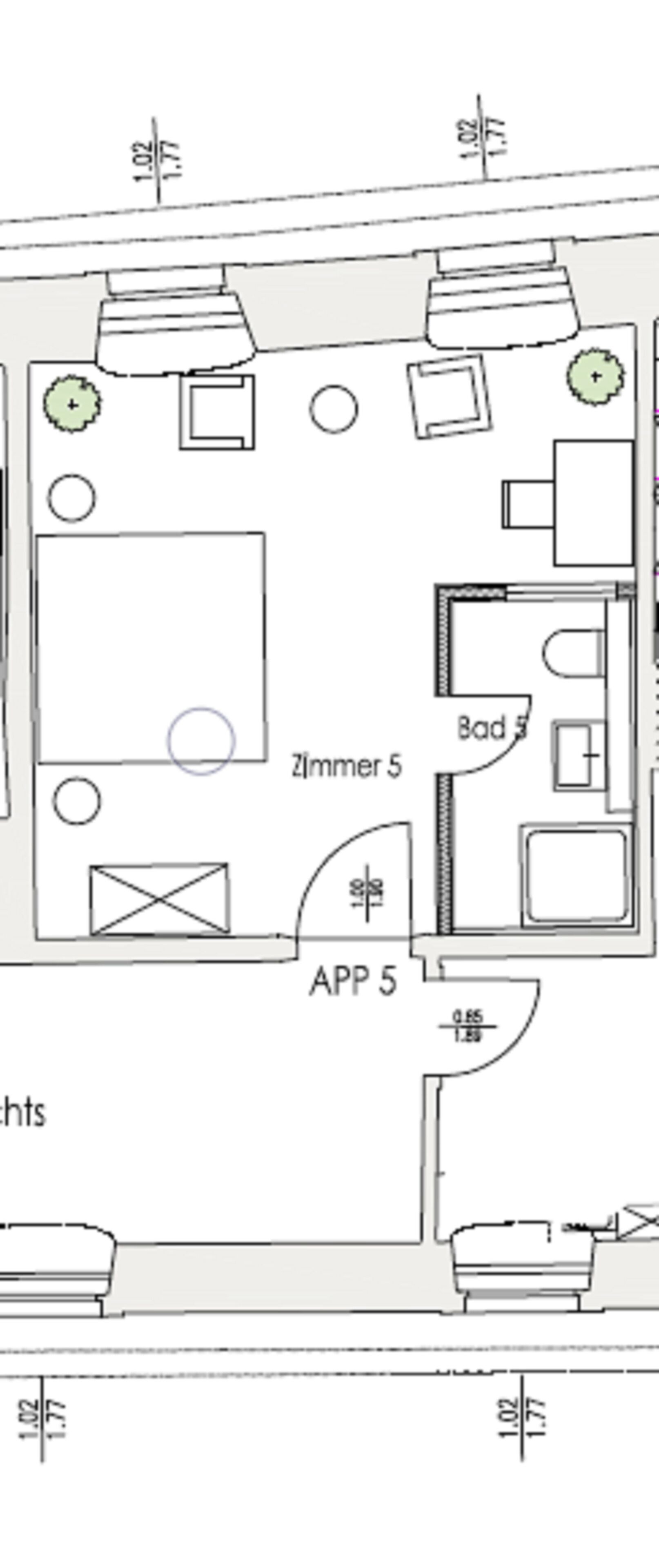 A floor plan of a hotel room with a large bed, a desk, a chair, a bathroom, and a small seating area.