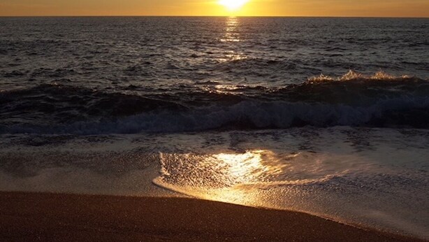A sunset over the ocean with waves approaching the shore. - Facing the sea, 30 m from the beach, luxury villa, air-conditioned  (Serra-di-Ferro)