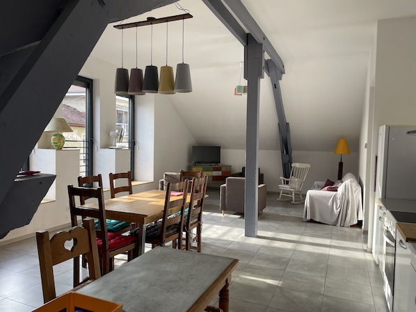 A spacious loft with a dining area, kitchen, and seating area. - Large apartment in the heart of La Côte Saint André (La Côte-Saint-André)