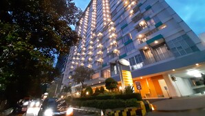 A multi-story hotel with a modern design, featuring numerous windows and balconies.