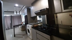 Una cocina moderna con lavadora, estufa y comedor con mesa y sillas.