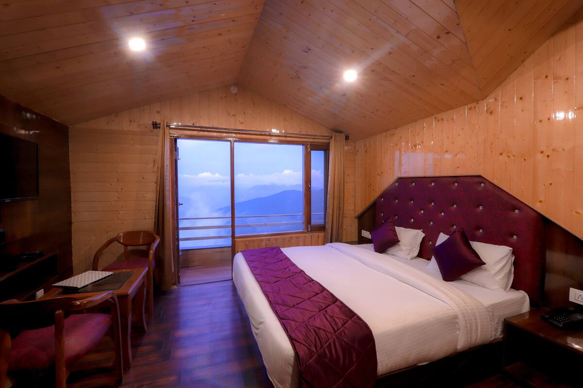 Una habitación de cabaña de madera con una cama, un escritorio y una silla.