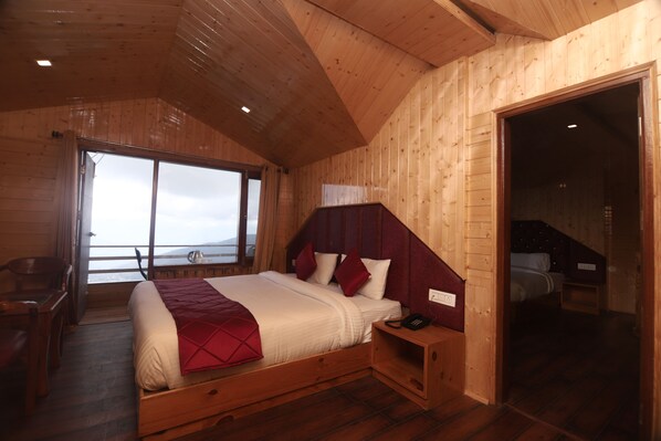 Dormitorio de cabaña de madera con una cama grande, un escritorio y una silla.