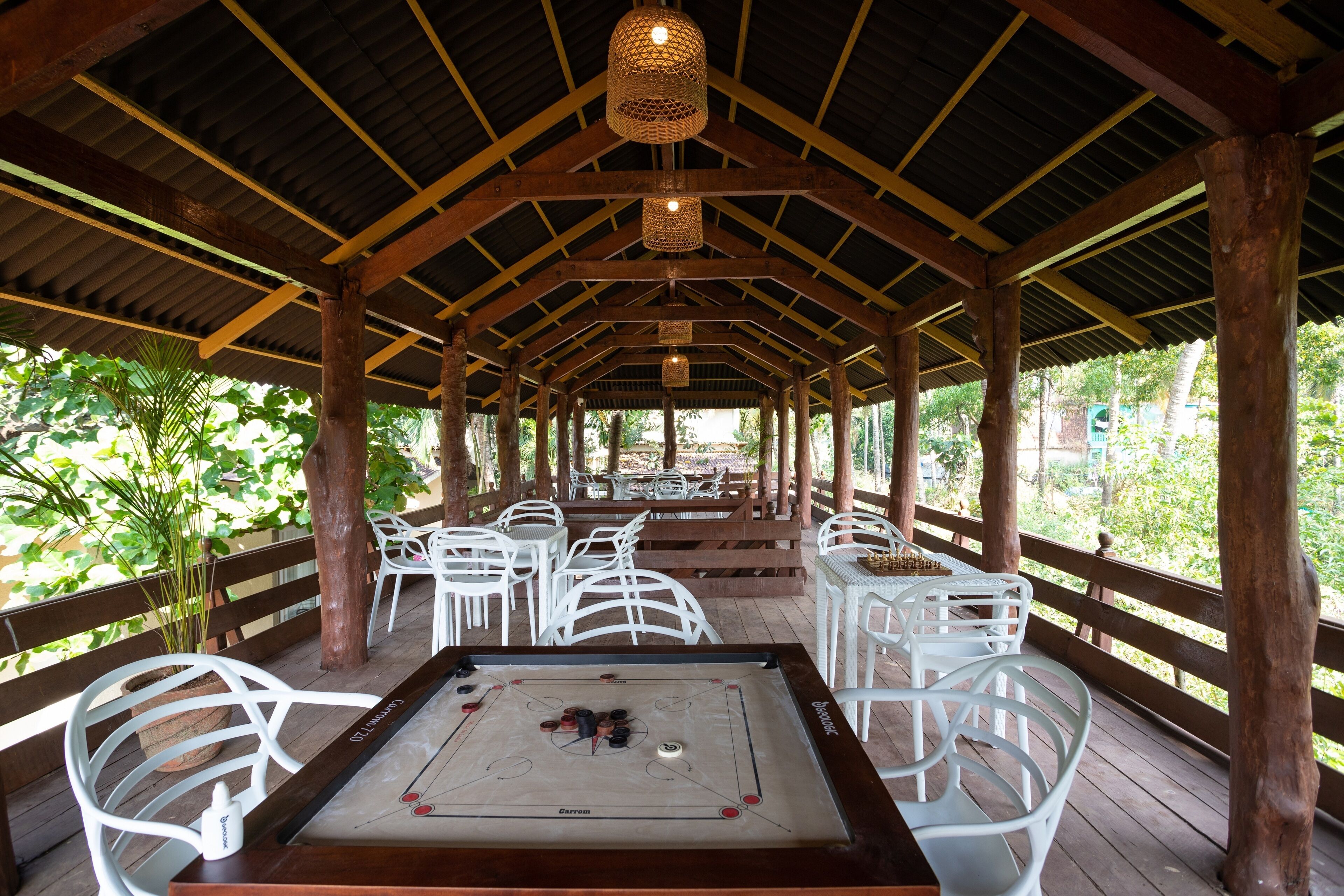 An indoor recreational area with a foosball table, white plastic chairs, and a wooden deck.