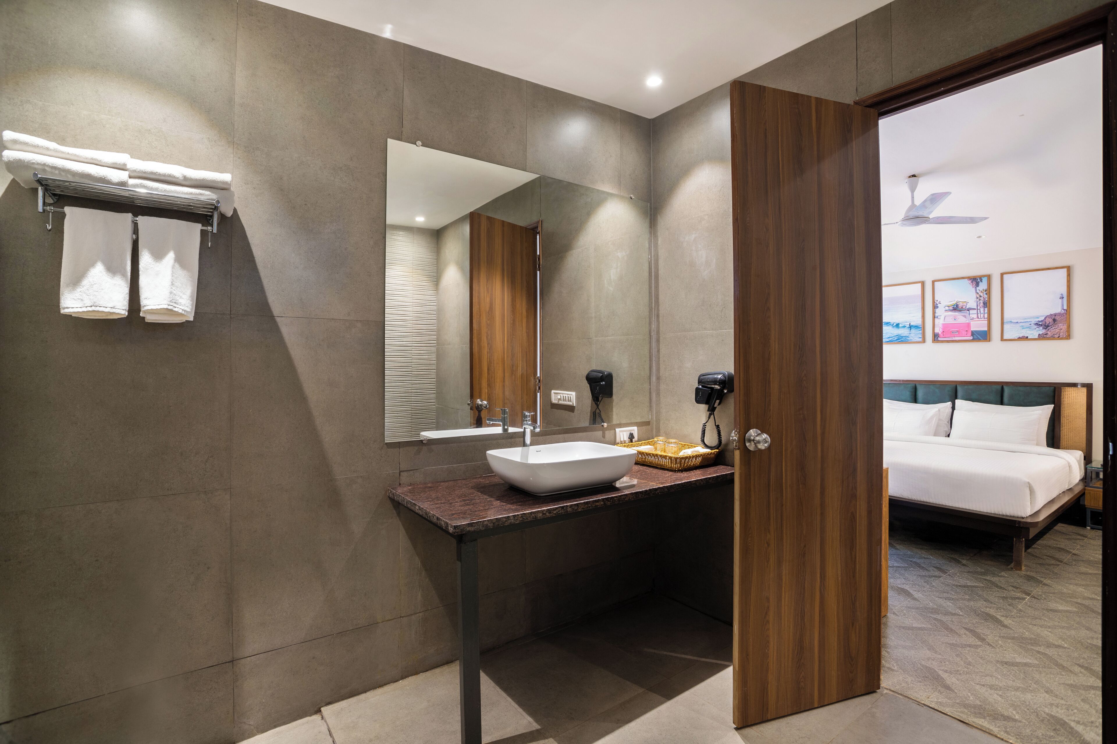 A modern bathroom with a large mirror, a vessel sink, and a wooden vanity.