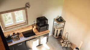 Eine moderne Küche mit Fenster, Einbauherd und Essbereich inklusive Sofa und Tisch.