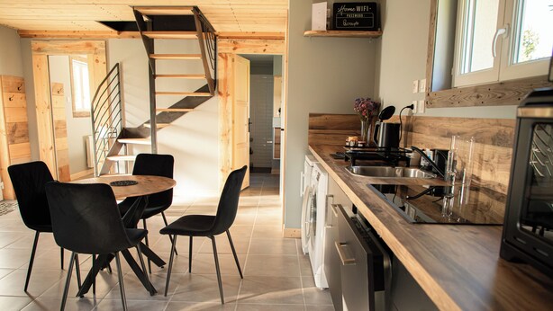 Eine moderne Küche mit einer Holz Arbeitsplatte, einem eingebauten Geschirrspüler und einer Edelstahl-Spüle.