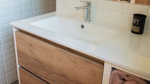 A bathroom with a white sink, wooden vanity, and a mirror. - LA TRANQUILITE NORMANDE Country cottage surrounded by animals! (Livarot-Pays-d'Auge)