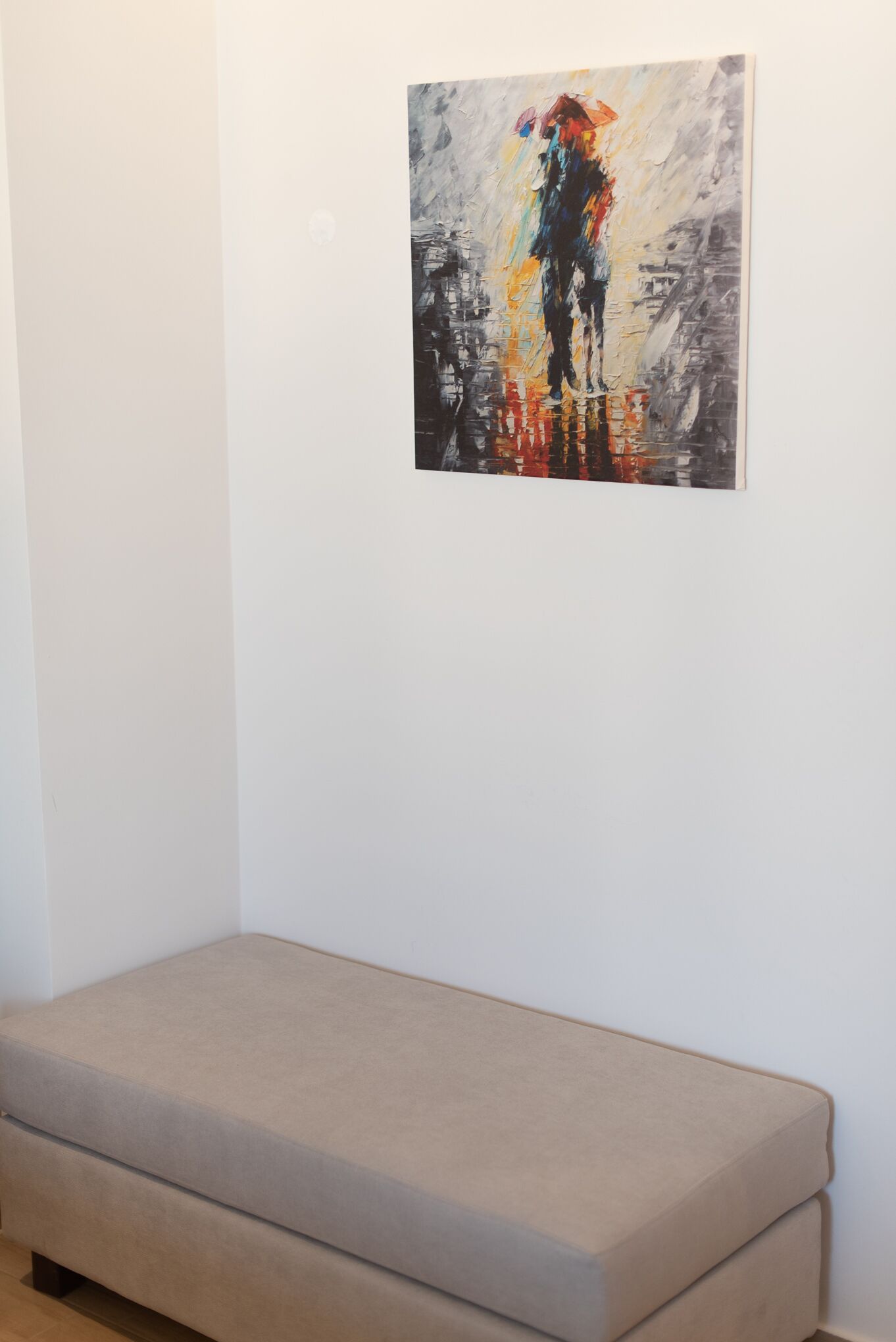 Een kamer met een bed en een schilderij aan de muur.