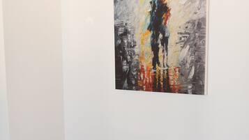 Ein Zimmer mit einem Bett und einem Gemälde an der Wand.