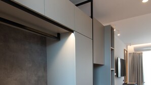 A modern living room with built-in seating, a flat-screen TV, and a minimalist design. - The Residences Kalamata (Kalamata)