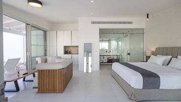 A modern hotel room with a large bed, a desk, and a seating area.