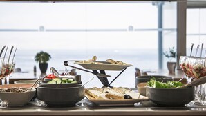 A buffet table with various dishes and a view of the sea. -  Ray Hotel Corfu (Corfu)