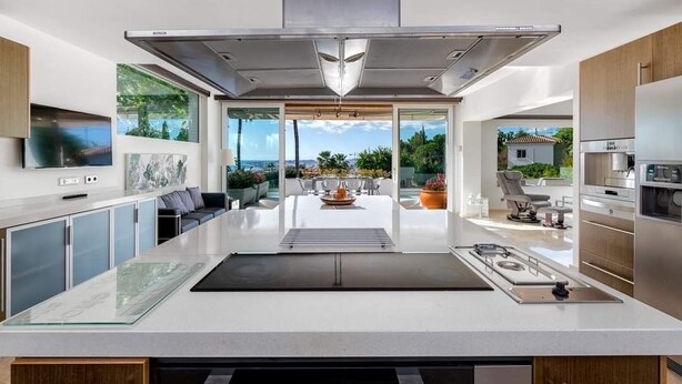 A modern kitchen with a central island, large windows, and a view of the outdoors. - Villa Catalina (Benalmádena)