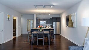 A modern kitchen with dark cabinets, a central island, and stainless steel appliances.