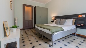 Ein Schlafzimmer mit Bett, Nachttisch, Lampe und einer Tür.
