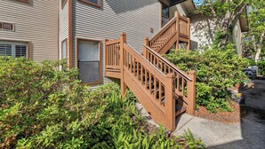 A two-story building with a wooden staircase leading to the upper floor. - 2br/2ba Walk to pier/village area.  1/2 mile to beach (Saint Simons Island)