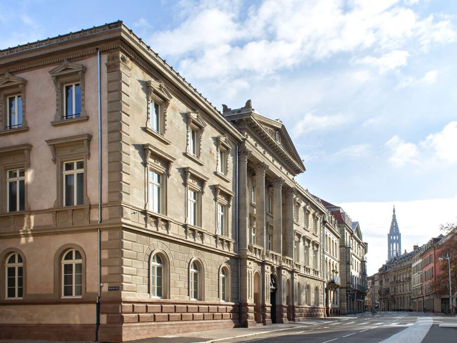 A historic building with classical architecture, featuring arched windows and columns.