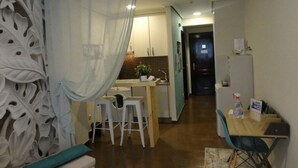 Une cuisine compacte avec un coin repas, une petite table et une chaise.