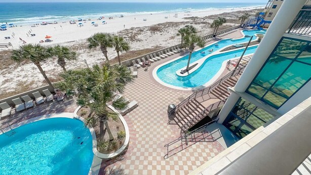 A resort with a pool area, beach view, and a lifeguard tower. - 3rd Floor!! New Owner, New to the Rental Market, Lazy River and Slide!! (Orange Beach)