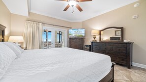 A bedroom with a large bed, a dresser, a ceiling fan, and a view of the outdoors. - 3rd Floor!! New Owner, New to the Rental Market, Lazy River and Slide!! (Orange Beach)
