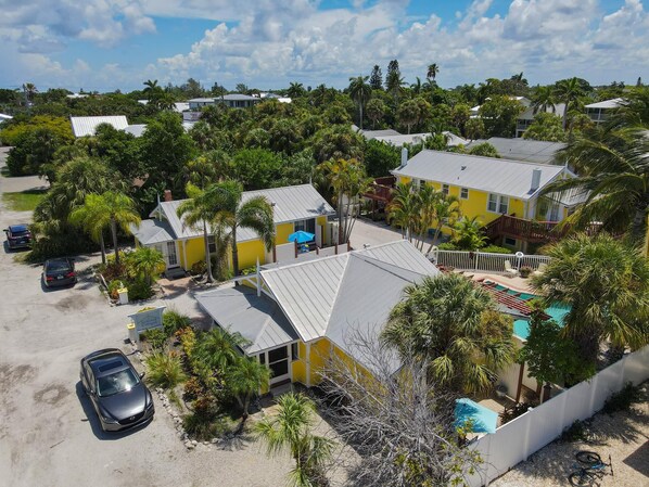 A residential area with multiple houses, a swimming pool, and a parked car.