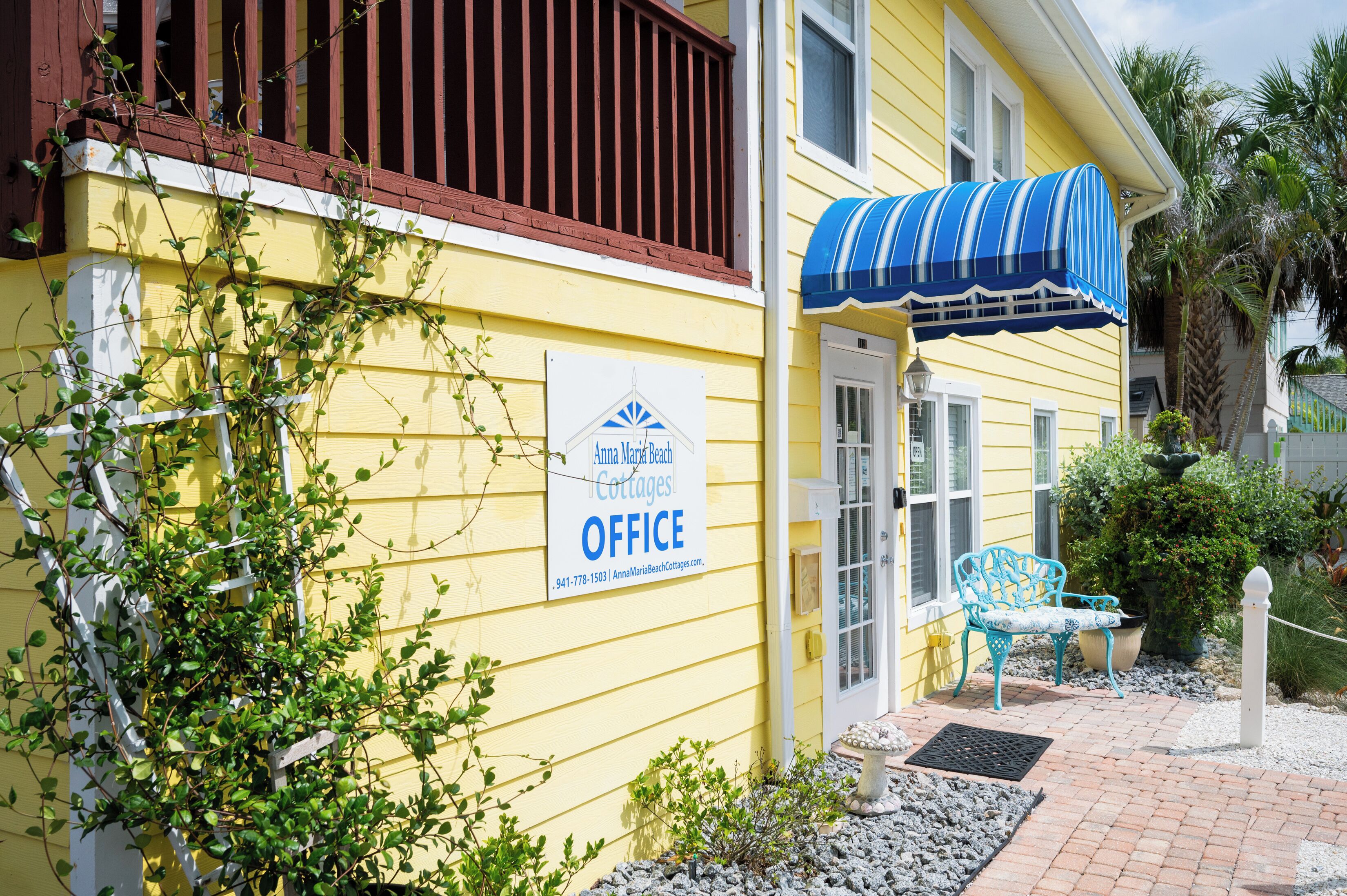 Edificio amarillo con un letrero que indica la oficina de Anna Maria Beach Cottages.