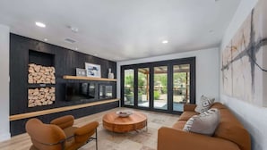 A modern living room with a fireplace, sofa, and coffee table. - @ Marbella Lane - The Wine Mine Desert Escape (Joshua Tree)
