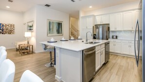 A modern kitchen with white cabinetry, stainless steel appliances, and a central island. - Luxury 5 Star Villa on Solterra Resort,minutes From Disney World, Orlando Mansion 2750 (Davenport)