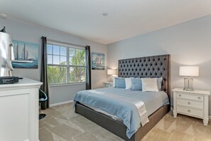 A bedroom with a large bed, two bedside tables with lamps, a window with curtains, and a painting of sailboats. - Luxury 5 Star Villa on Solterra Resort,minutes From Disney World, Orlando Mansion 2750 (Davenport)