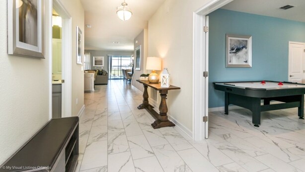 A hallway with a pool table, a bench, and a dining area in the background. - Luxury Mansion on Storey Lake Resort, Minutes From Disney World, Orlando Mansion 2672 (Kissimmee)