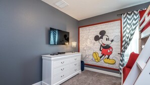 A child's room with a Mickey Mouse mural, a white dresser, and a TV on the wall. - Amazing Villa on Champions Gate Resort With the Best 5 Star Amenities, Orlando Villa 2846 (Davenport)