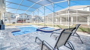 A covered outdoor swimming pool with lounge chairs, a hot tub, and a patio area. - Luxury Holiday Mansion Minutes From Disney on Champions Gate Resort, Orlando Mansion 2596 (Davenport)