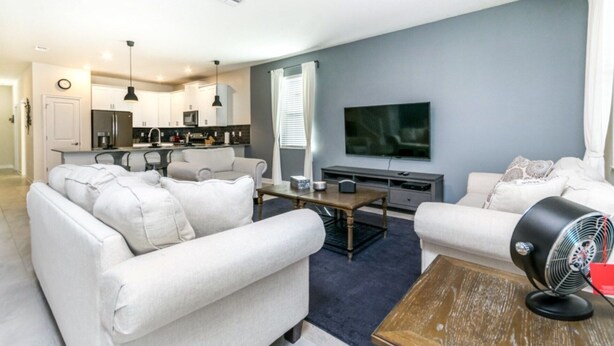 A modern living room with a sofa, a coffee table, and a TV. - Luxury Holiday Mansion Minutes From Disney on Champions Gate Resort, Orlando Mansion 2596 (Davenport)