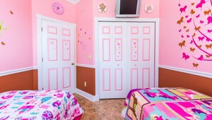 A pink-themed bedroom with two beds, a television above the door, and butterfly wall decals. - Luxury 5 Star Villa on Highlands Reserve Resort, Orlando Villa 2748 (Davenport)