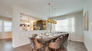A dining area with a long table set for six, surrounded by six chairs.