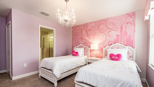 A bedroom with two beds, a chandelier, and a pink-themed wall. - Your Beautiful Mansion Close to Disney on the Prestigious Champions Gate Resort, Orlando Mansion 2508 (Davenport)