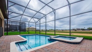 A swimming pool with a brick deck and a glass enclosure. - Your Beautiful Mansion Close to Disney on the Prestigious Champions Gate Resort, Orlando Mansion 2508 (Davenport)