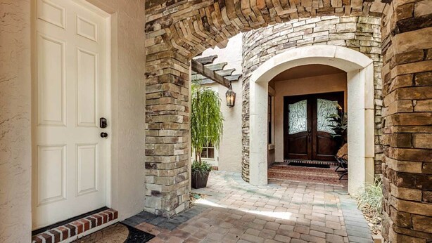 A stone archway leading to a door with a decorative glass panel. - 5 Star Villa on Orlandos Most Exclusive Reunion Resort and Spa, Orlando Villa 4599 (Kissimmee)