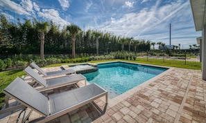A rectangular swimming pool with a hot tub, surrounded by a brick patio and lounge chairs. - 5 Star Villa on Encore Resort at Reunion With Large Private Pool, Orlando Villa 4493 (Kissimmee)
