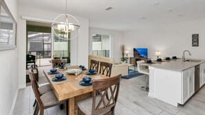 Een moderne keuken met een houten eettafel, witte kasten en een centraal eiland.